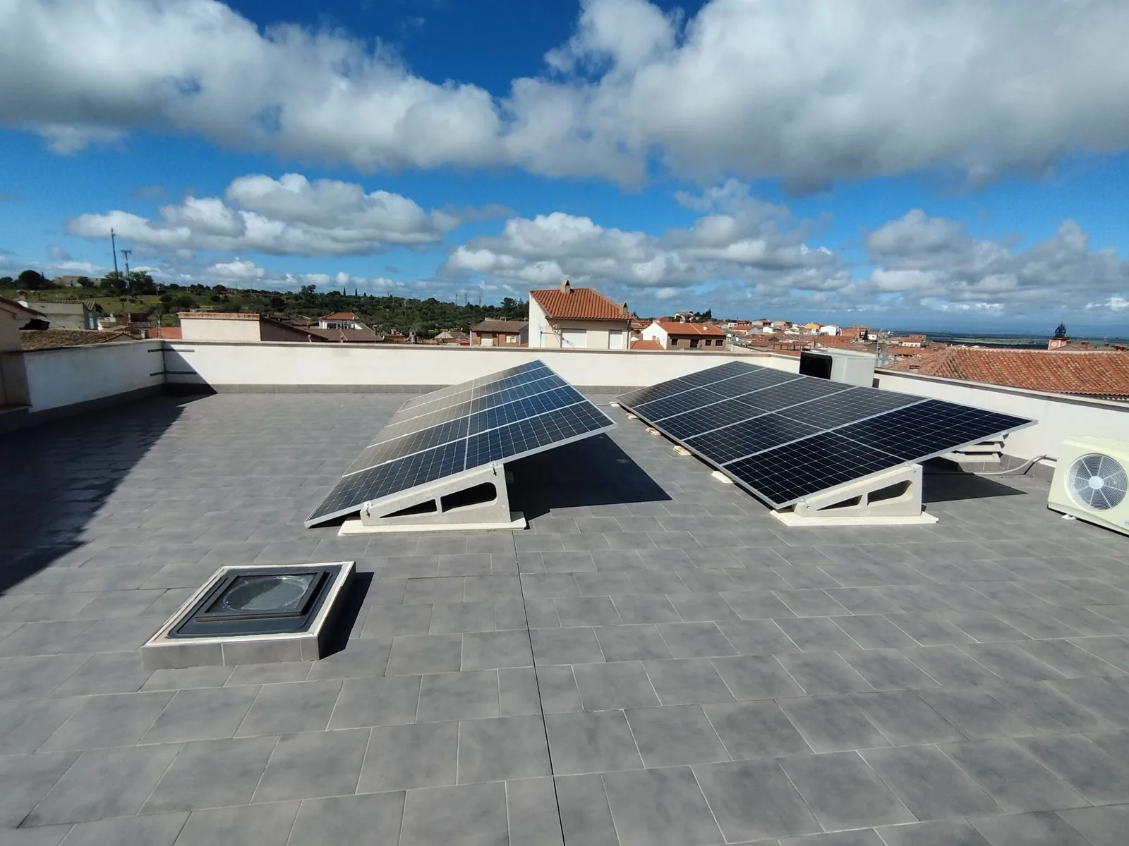 Vista lateral de las estructuras que inclinan los paneles solares sobre una cubierta plana